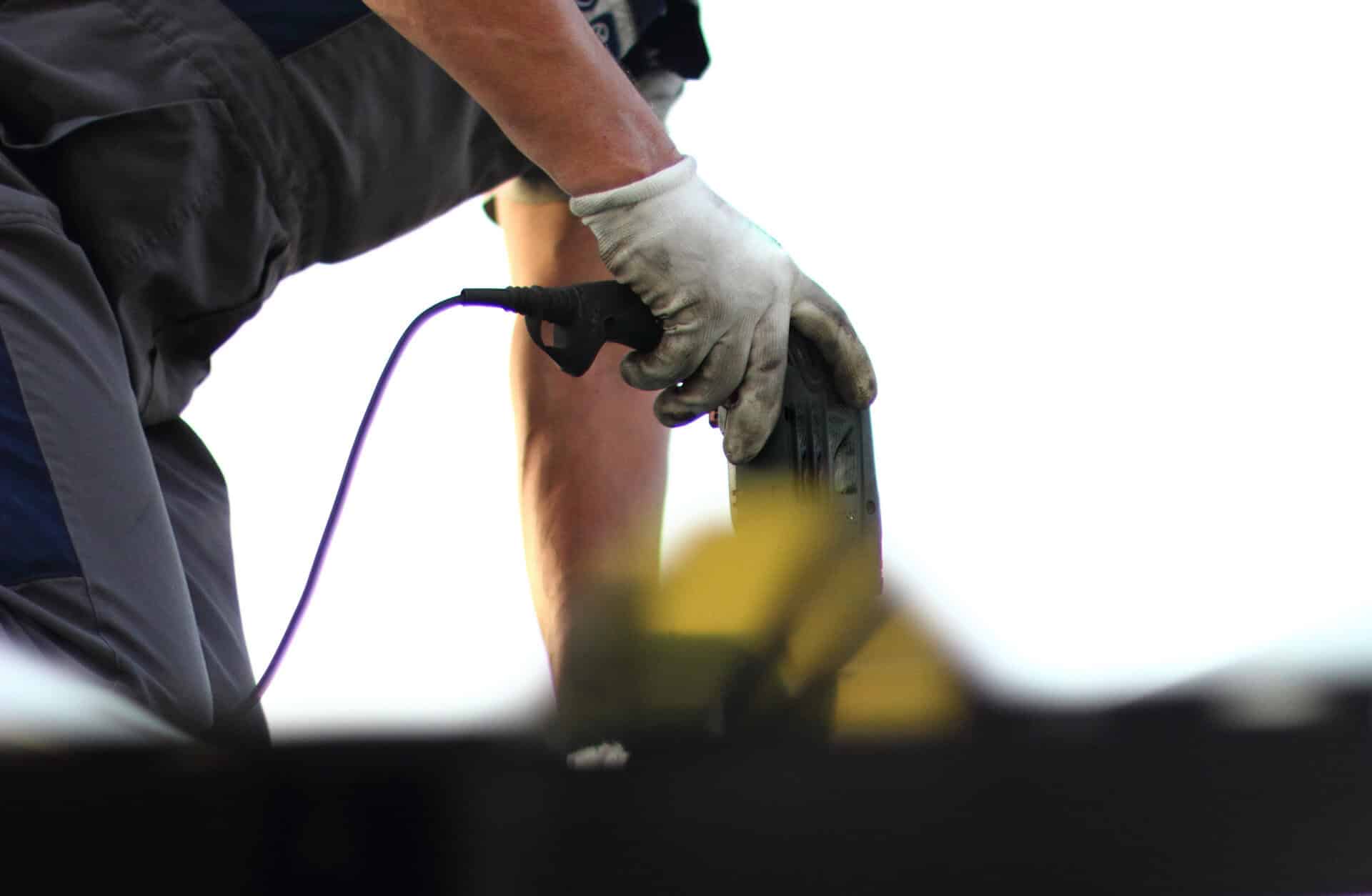 A roofer work to make repairs on a commercial roof.